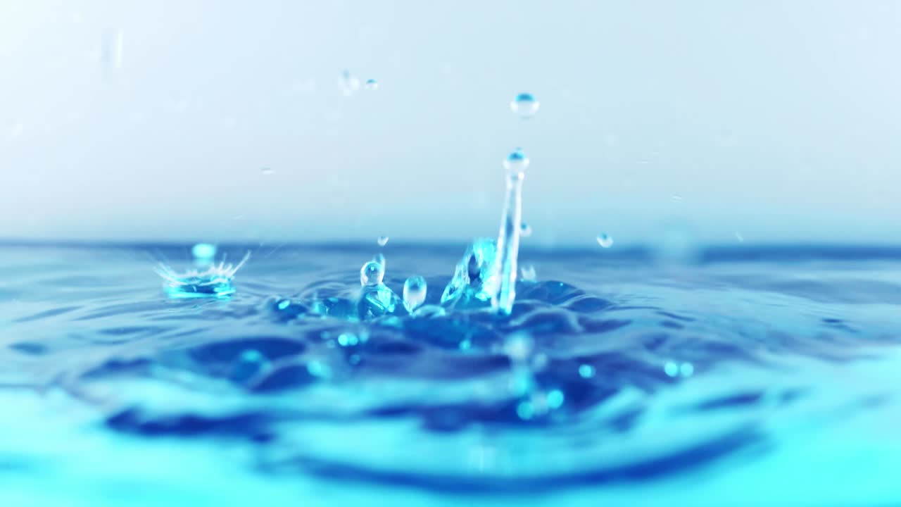 The clean water surface in slow motion fills the screen with water splashing shop the water drop and waving liquid surface with an air bubble