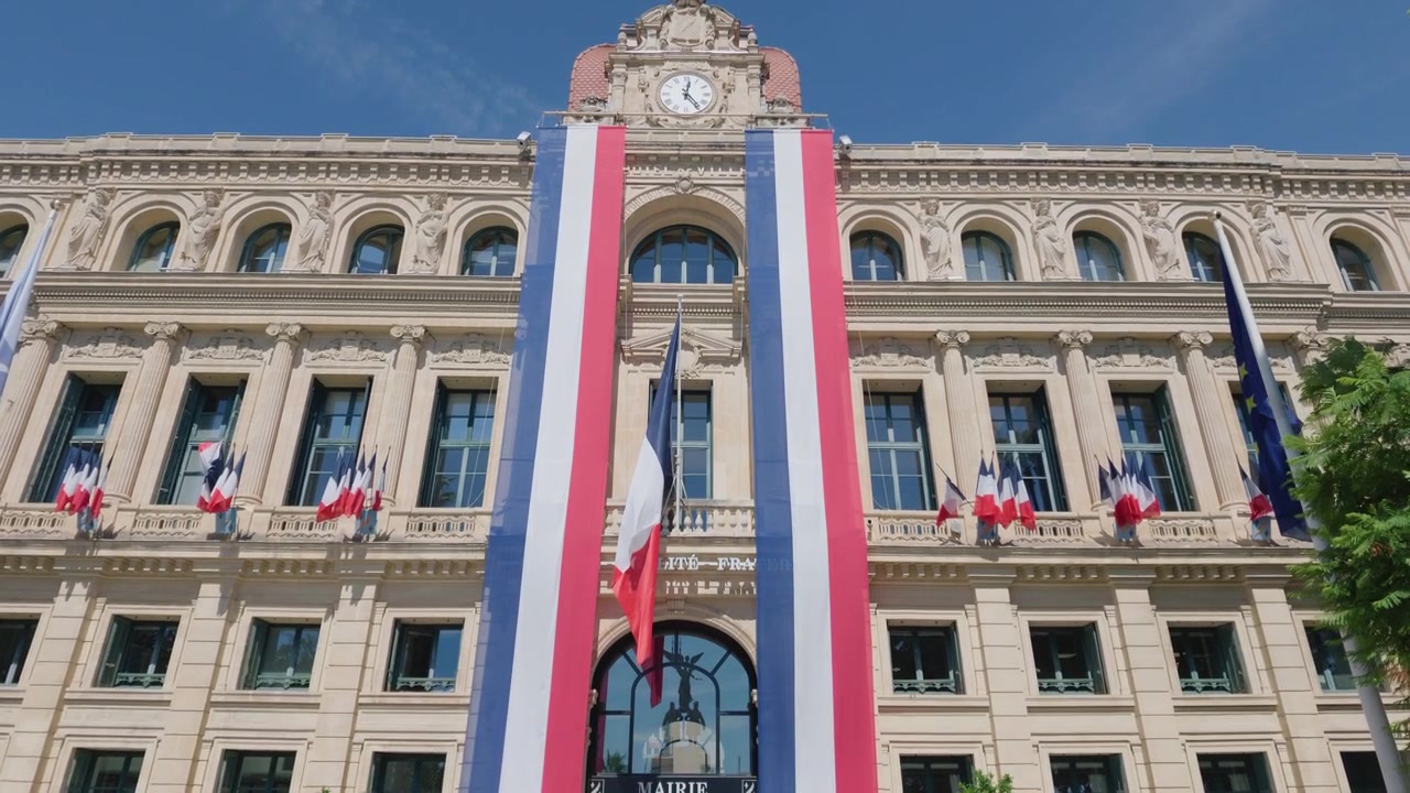 Vista panorámica del Hotel de Ville con una torre de reloj, banderas francesas y estandartes tricolores, Cannes, Francia