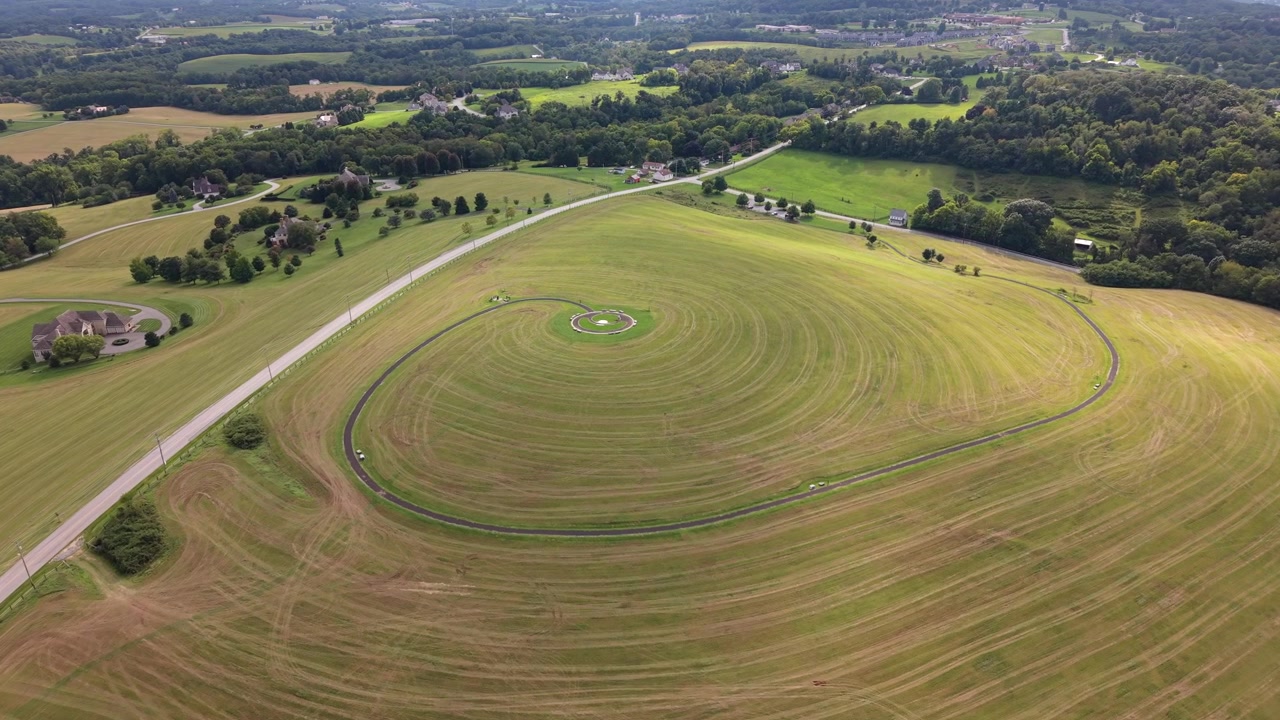 An aerial drone shot capturing Highpoint Scenic Vista showing circular walking paths grassy fields and rolling hills in rural Pennsylvania.