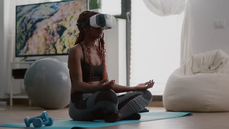 black trainer woman wearing virtual reality headset while sitting on yoga map