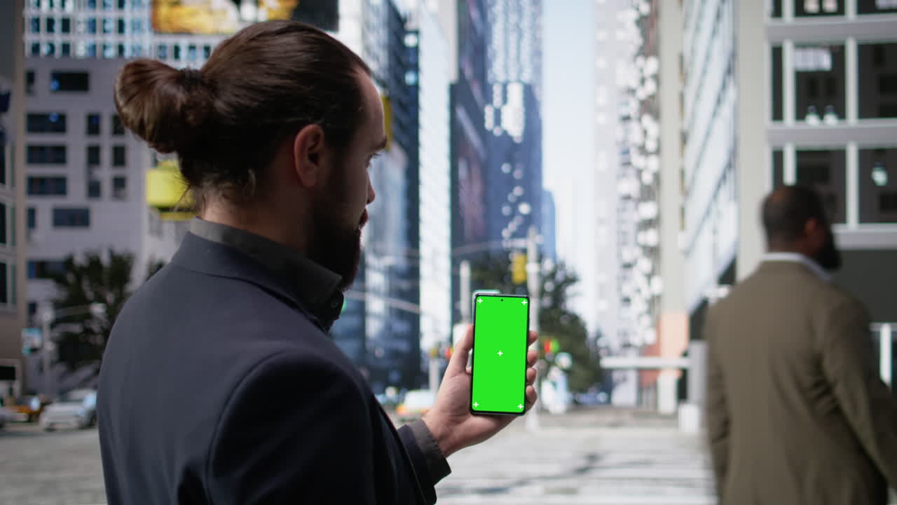 Vertical green screen on phone with male pedestrian walking along busy street
