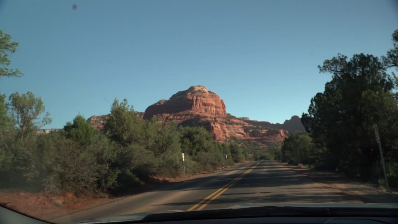 Beautiful monumental views of the desert rock formation in front of the car while driving on the small road in Arizona near Sedona at the end of summer 2018