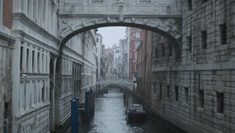 Slow-handheld-slider-shot-of-Venetian-canal-under-the-bridge-of-sighs