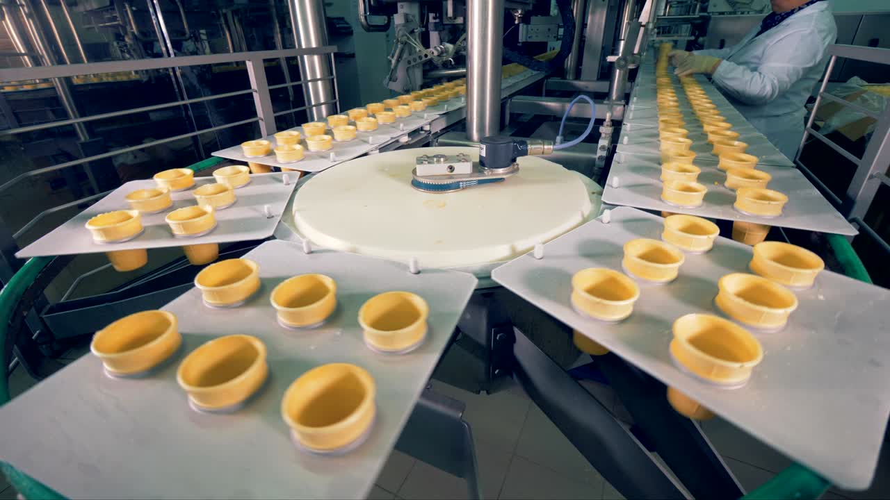 Plates with inserted empty wafer cups are moving in an arc. 4K.