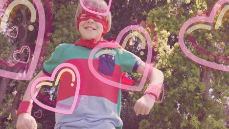 child wearing superhero costume with heart animations over sunny outdoor background