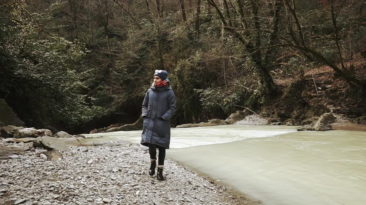 겨울에 강 의 숲에서 산책하는 여자