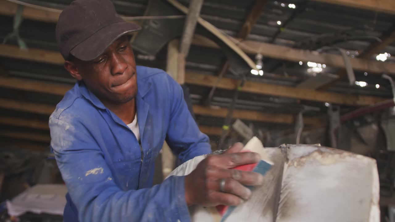 African man sanding a car