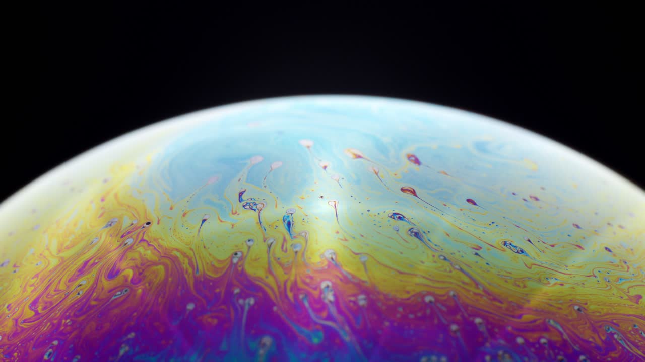 мыльный пузырь: красочные вихри и абстрактные узоры, изолированные на черном фоне.