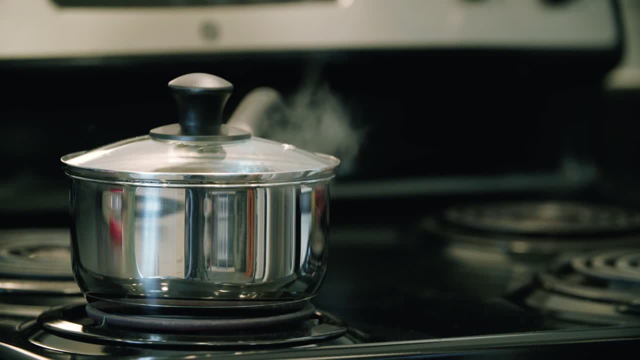 Water boiling on a stove in a sauce pan in an unattended scenario.