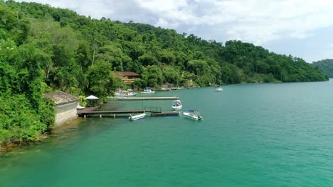 aerial drone shot along coastline of a beautiful tropical vegetation and turquoise calm ocean