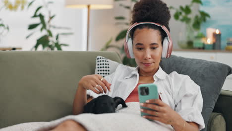 woman relaxing on couch with headphones and phone