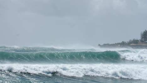fuertes olas y surfistas en el océano durante la temporada de ciclones en la costa de australia, cámara lenta