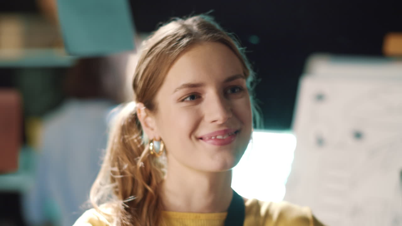 Young business woman enjoying job process in office. Smiling girl working late