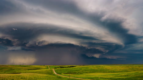 dramatic supercell storm over green prairie landscape