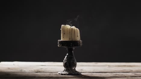 video de una vela de halloween con humo y espacio de copia sobre un fondo de madera y negro