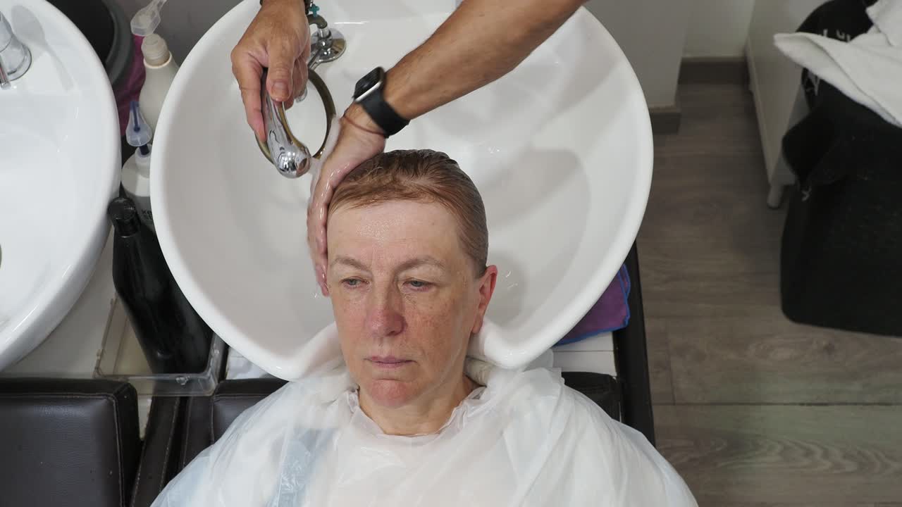 여성이 미용실에서 머리를 고 있습니다.