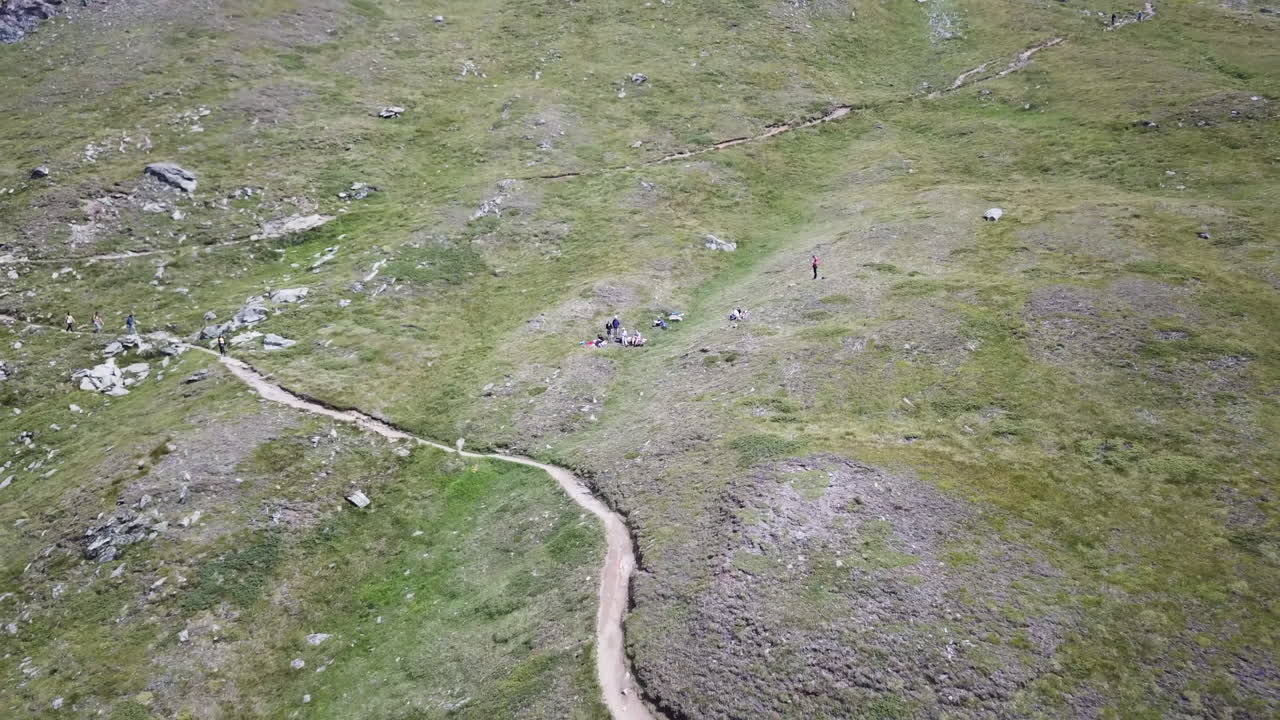 prado en los alpes suizos, vista aérea de drones, césped y un sendero para caminantes y ciclistas, actividad deportiva de montaña en la naturaleza