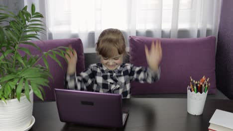 Girl-doing-lessons-at-home-using-digital-laptop-computer.-Distance-education