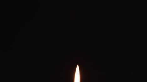 Video-of-white-candle-with-white-flame-and-copy-space-on-black-background