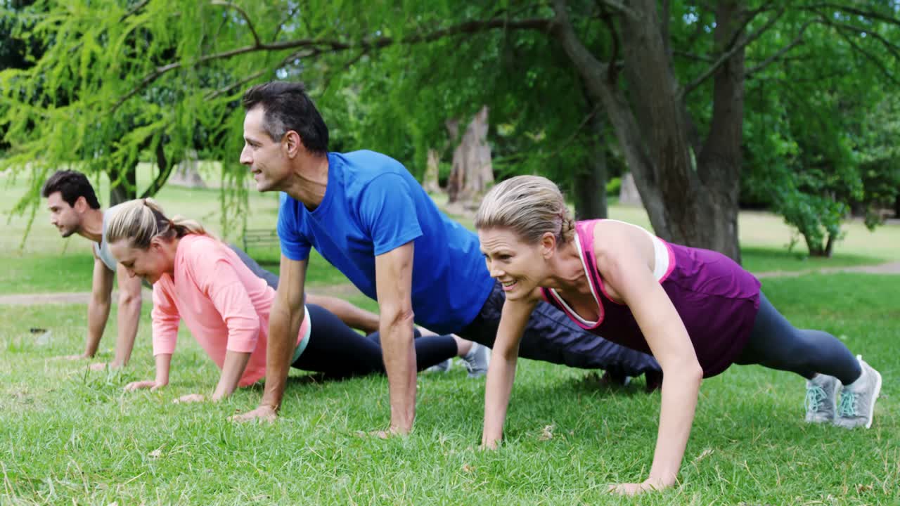 grupo de personas haciendo ejercicios de flexión juntos en el parque