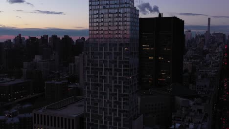 drone flyby of highrise skyscraper in new york city, glittering in the sunrise daybreak light