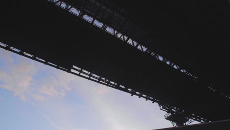 tilting gimbal shot of the underside of the brooklyn bridge on the streets of dumbo