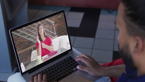 hombre de negocios afroamericano usando una computadora portátil haciendo una videollamada con una colega