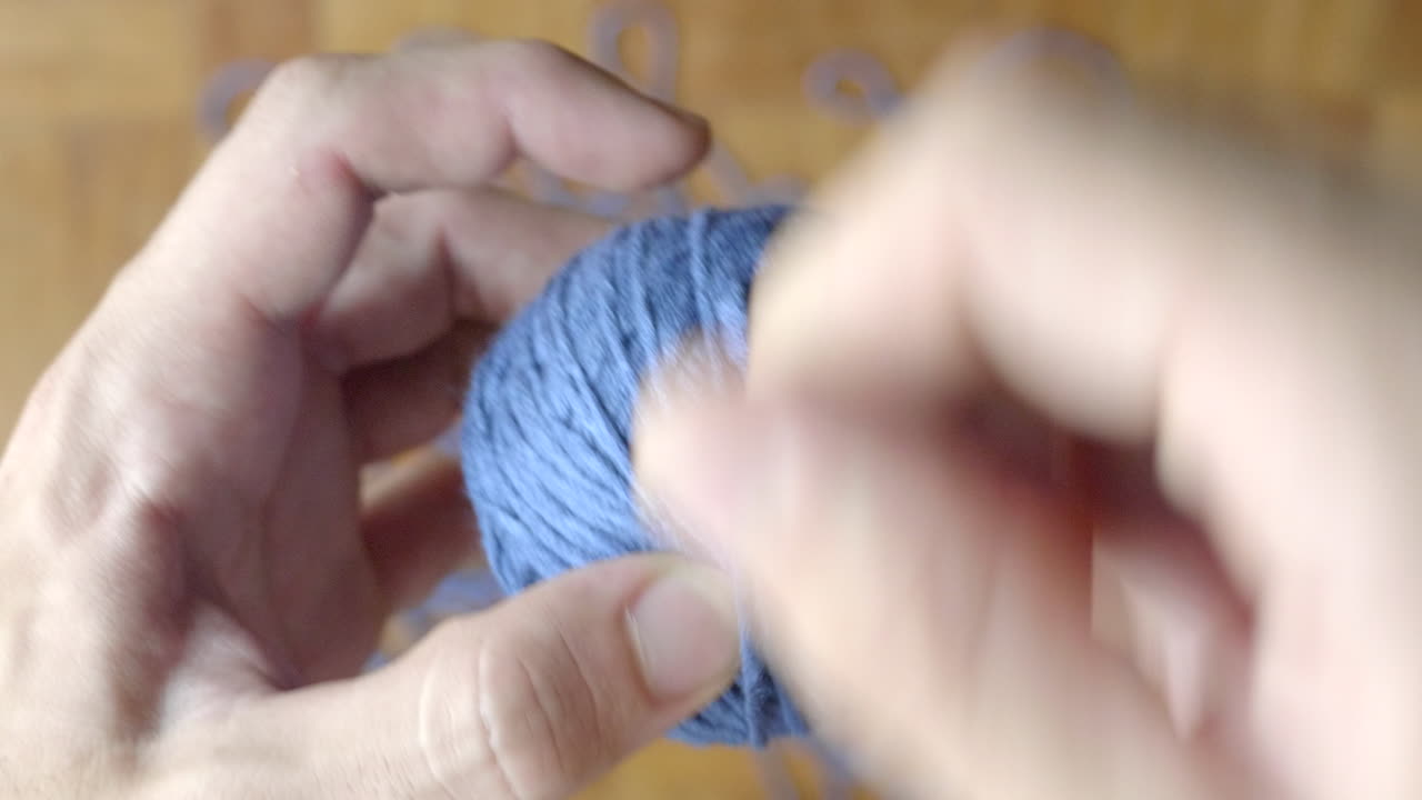 파란색 모직 공을 감는 손 클로즈업