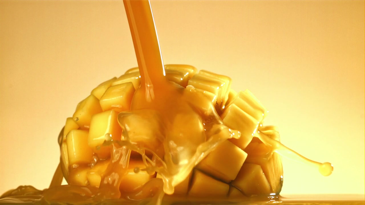 Succo versato su mango a cubetti al rallentatore