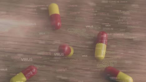 Animation-of-multiple-floating-Covid-19-words-over-falling-pills-on-a-table