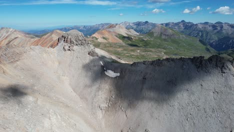 cinematic aerial view, clouds shadows above steep rocky hills of mountains in countryside of colorado usa