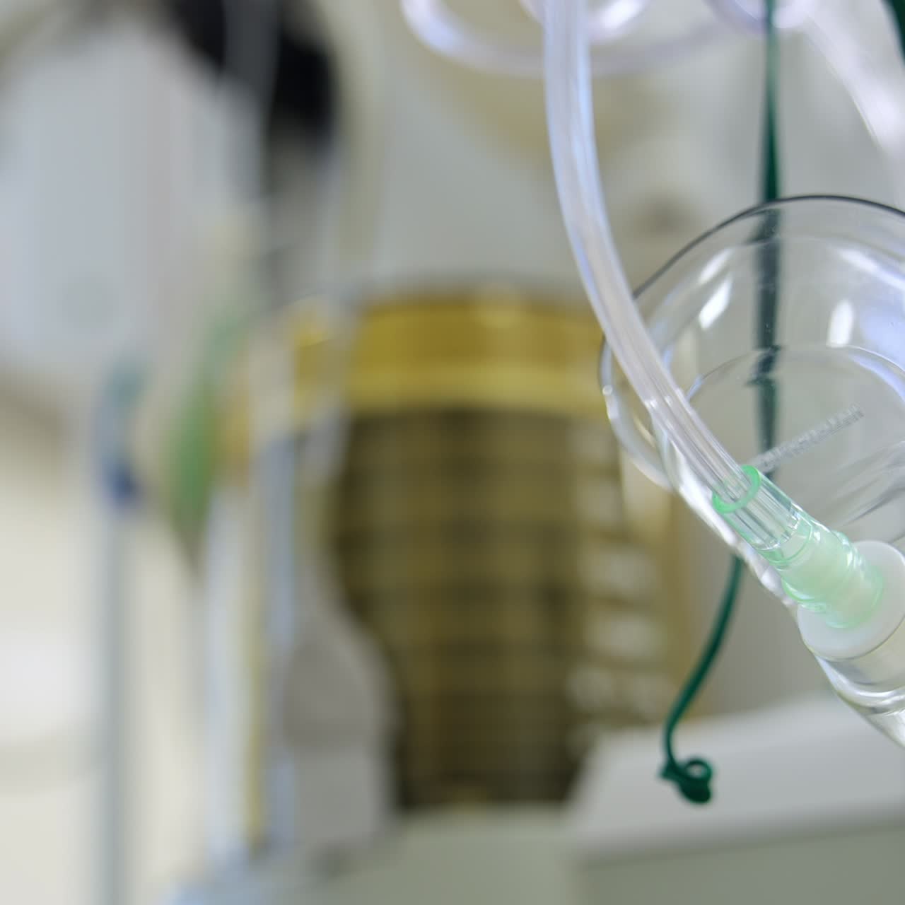 Breathing transparent oxygen mask hanging in the surgery room. Low angle view. Artificial lung ventilation machine working at backdrop