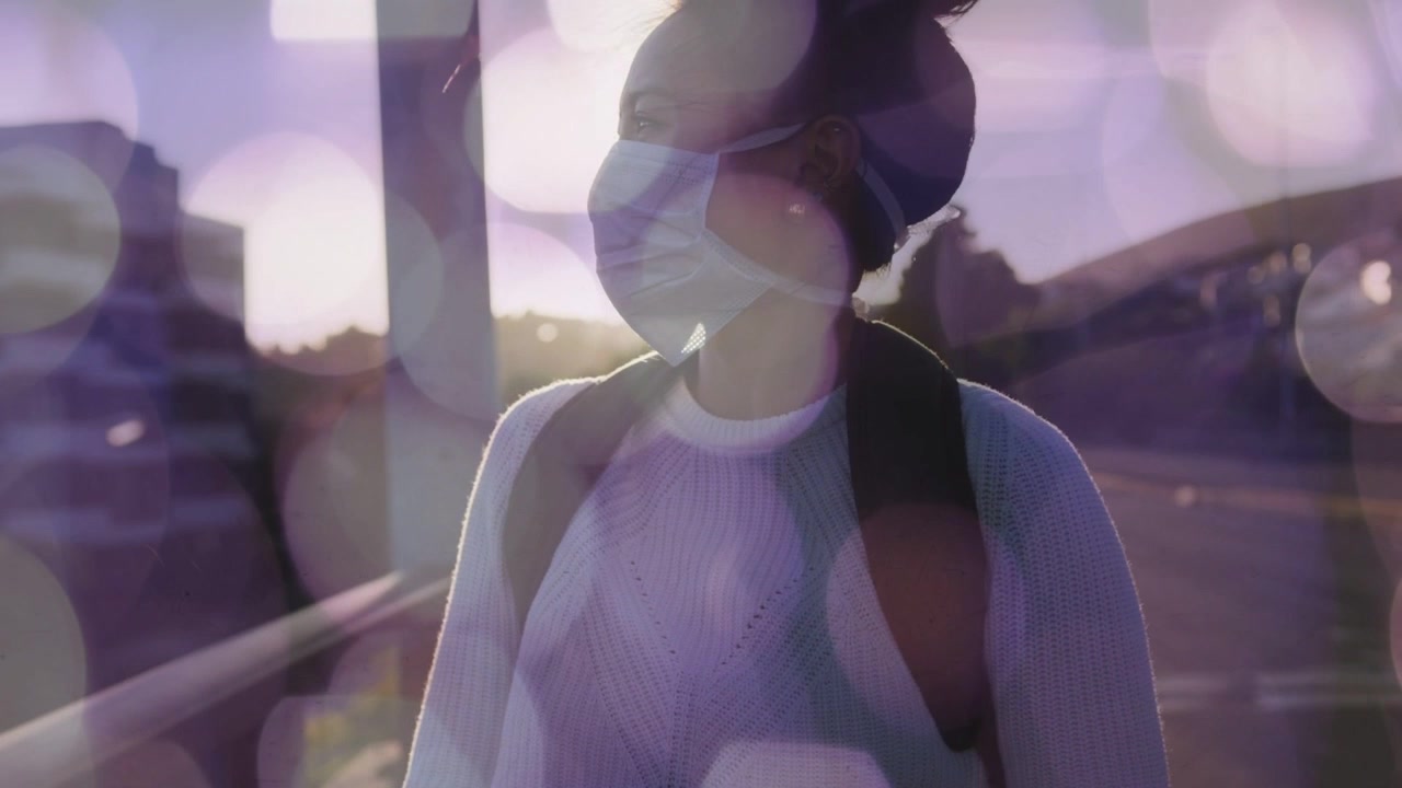 Donna in viaggio su una strada al tramonto, tiene in mano il telefono, il bagliore del sole le fa alzare lo sguardo, un riflesso dell'obiettivo oscura.