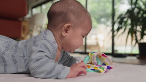 Zahnendes-Baby,-Das-Auf-Dem-Bauch-Mit-Spielzeug-Spielt