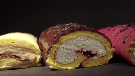 slider-shot-of-cake-rolls-brazo-gitano-swiss-roll-desserts-collection-chocolate-ferrero-cheese-butter-jelly-berries-cherry-with-black-background