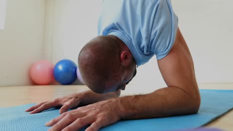 man exercising on mat in the fitness studio 4k