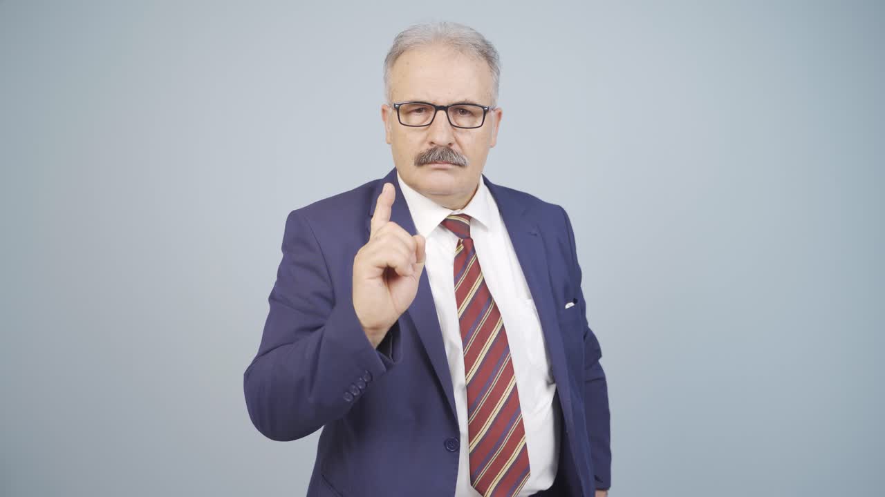 hombre de negocios alertando a la cámara con una expresión severa.