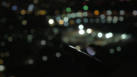 Close-up-shot-of-woman-reading-from-cellphones-on-bokeh-background