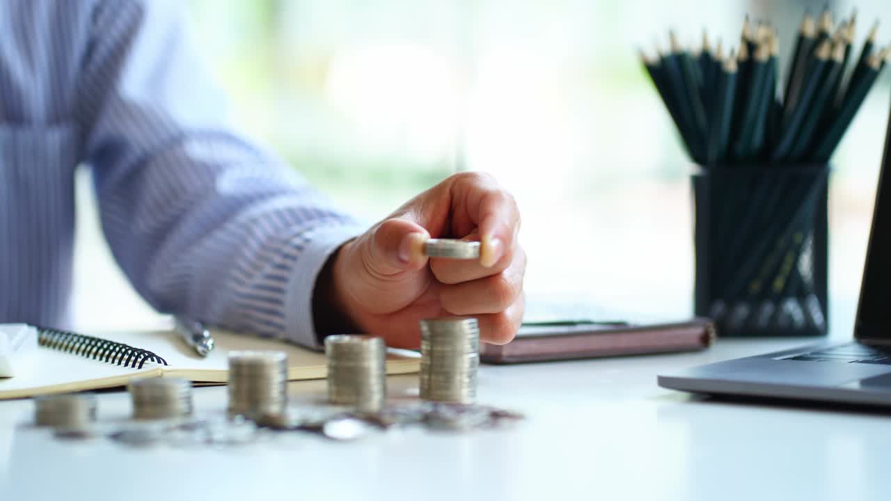 businessman or manager counting coins on the table Financial Crisis or Savings Ideas calculate cost Check the data from the calculator coin, schematic diagram on the table.