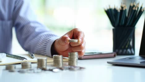 businessman or manager counting coins on the table financial crisis or savings ideas calculate cost check the data from the calculator coin, schematic diagram on the table.