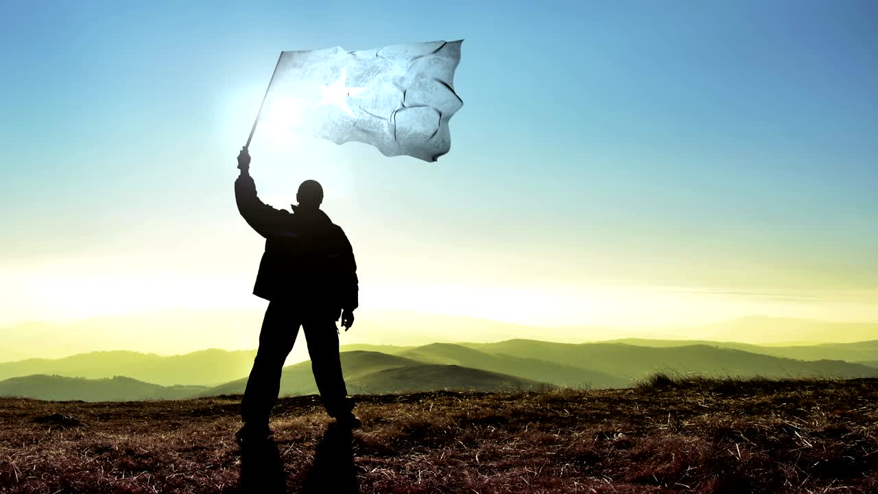 exitoso silueta hombre ganador agitando bandera de somalia en la parte superior del pico de la montaña, fondo de bucle cinemagraph