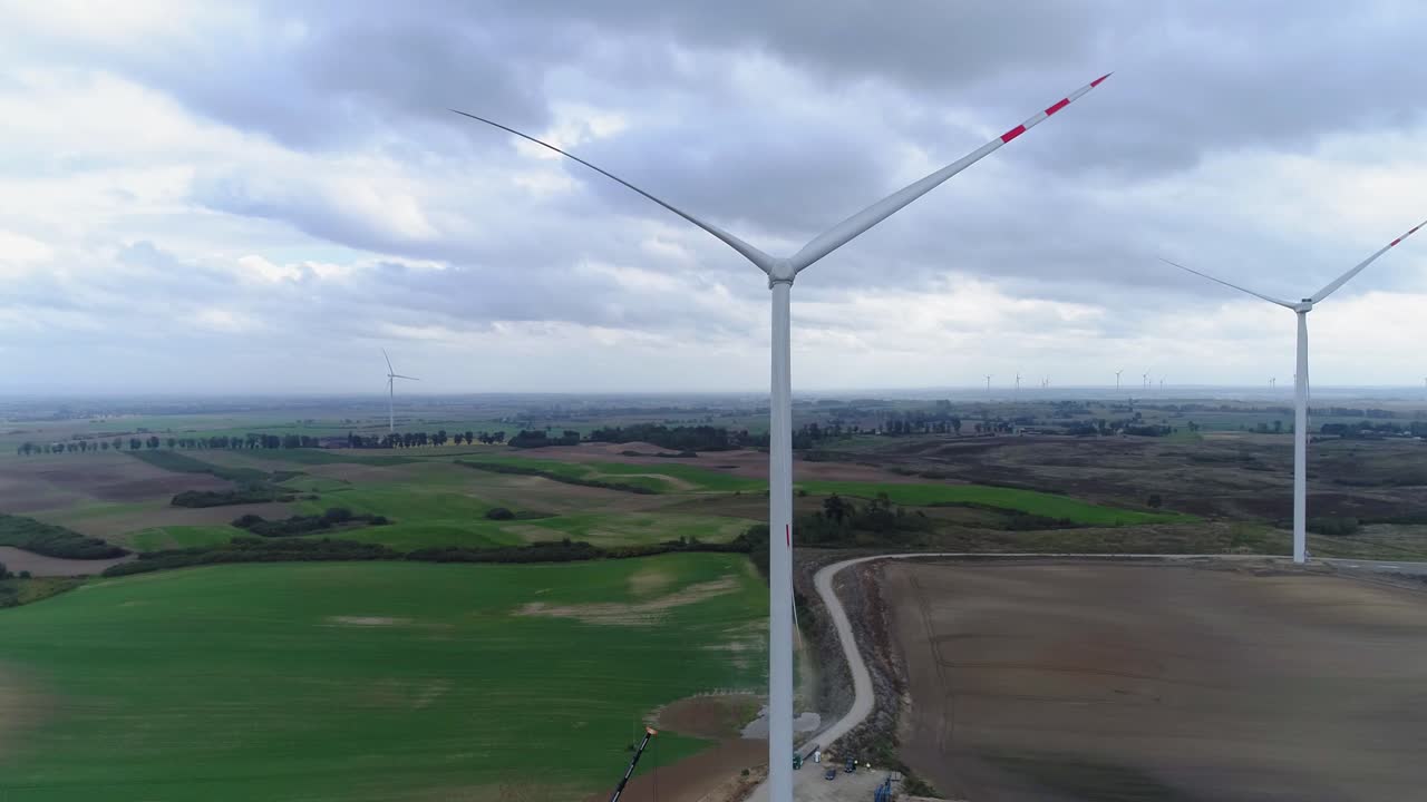 линия белых ветряных мельниц останавливает вращение на ветряной электростанции в пасмурный день в квидзине, польша - крупный план