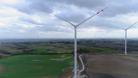 Eine-Reihe-Weißer-Windmühlen-Hört-Auf,-Sich-An-Einem-Bewölkten-Tag-In-Kwidzyn,-Polen,-In-Einem-Windpark-Zu-Drehen---Weitschuss