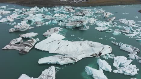 Vista-Aérea-De-Los-Icebergs-De-La-Laguna-Glacial-Jökulsárlón-Y-El-Agua-Turquesa,-Islandia