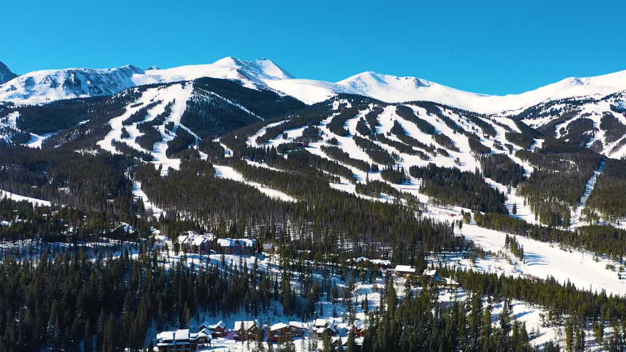 울창한 소나무 숲에서 야외 스포츠와 모험을 위해 준비된 스키 트레일과 함께 눈으로  ⁇ 인 겨울 산의 공중 드론 전망