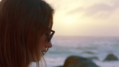 retrato de una hermosa mujer disfrutando de la tranquilidad de la playa al atardecer explorando la espiritualidad mirando hacia arriba orando contemplando el viaje relajándose en la playa usando gafas de sol