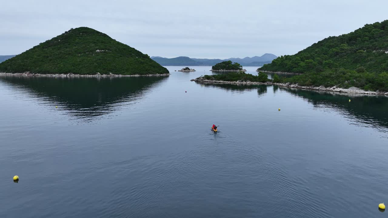 Tracking drone shot of a kayak sailing around Mljet Island in the day in Croatia