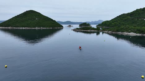 tracking drone shot of a kayak sailing around mljet island in the day in croatia