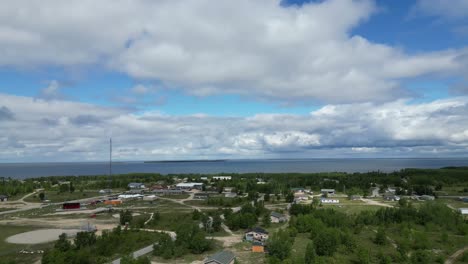 a moving aerial drone shot of a residential area and cedar lake in the easterville and chemawawin cree nation area during the summer months and overcast season