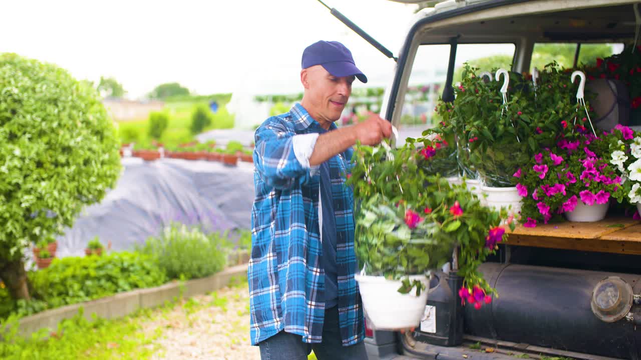 밴 트렁크에 화분을 싣고 있는 정원사